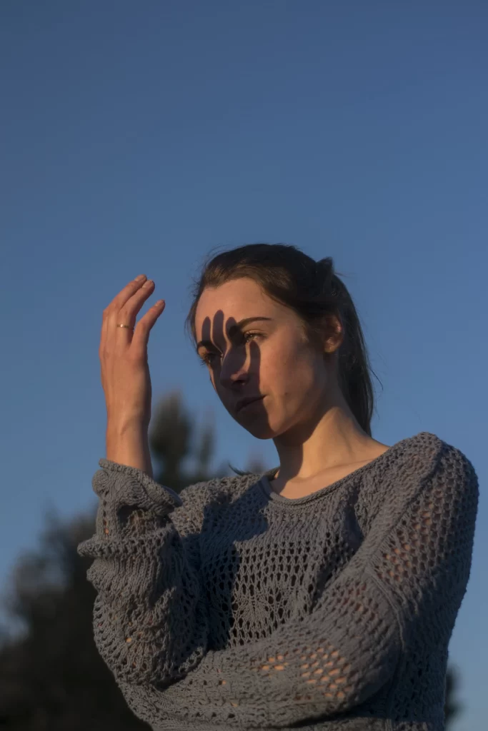 young-woman-looking-camera-against-blue-sky-min